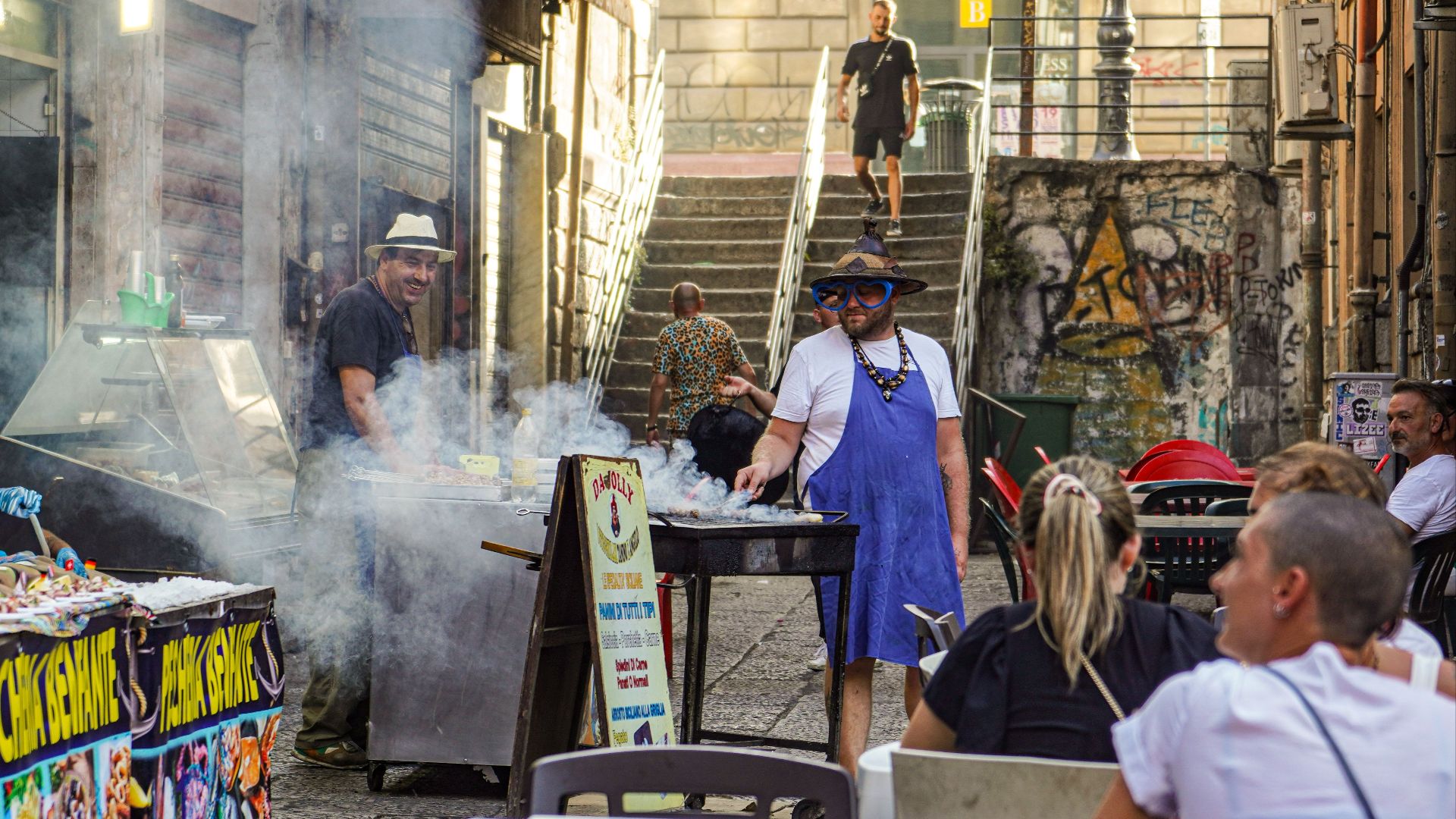 Vibrant street scene in Palermo, Sicily, capturing barbecue smoke and lively atmosphere.
