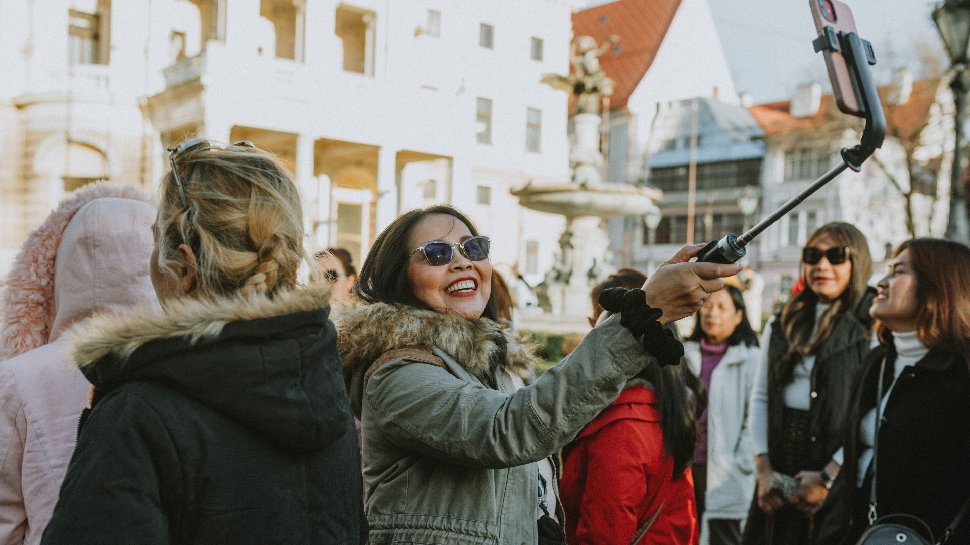 A group of tourists enjoys a city tour, capturing memories with a selfie in an urban setting.