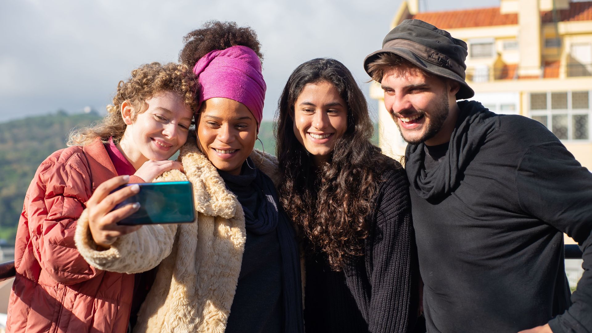 Diverse group of friends enjoying a selfie moment outdoors in Portugal.