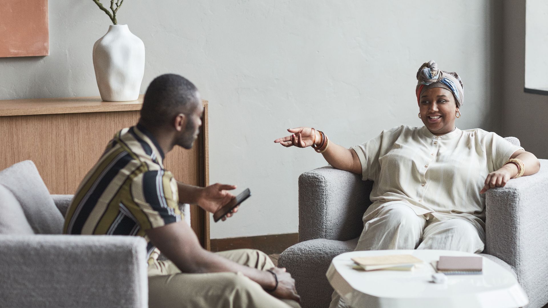 A warm and inviting scene of two people having a conversation in a modern living room.