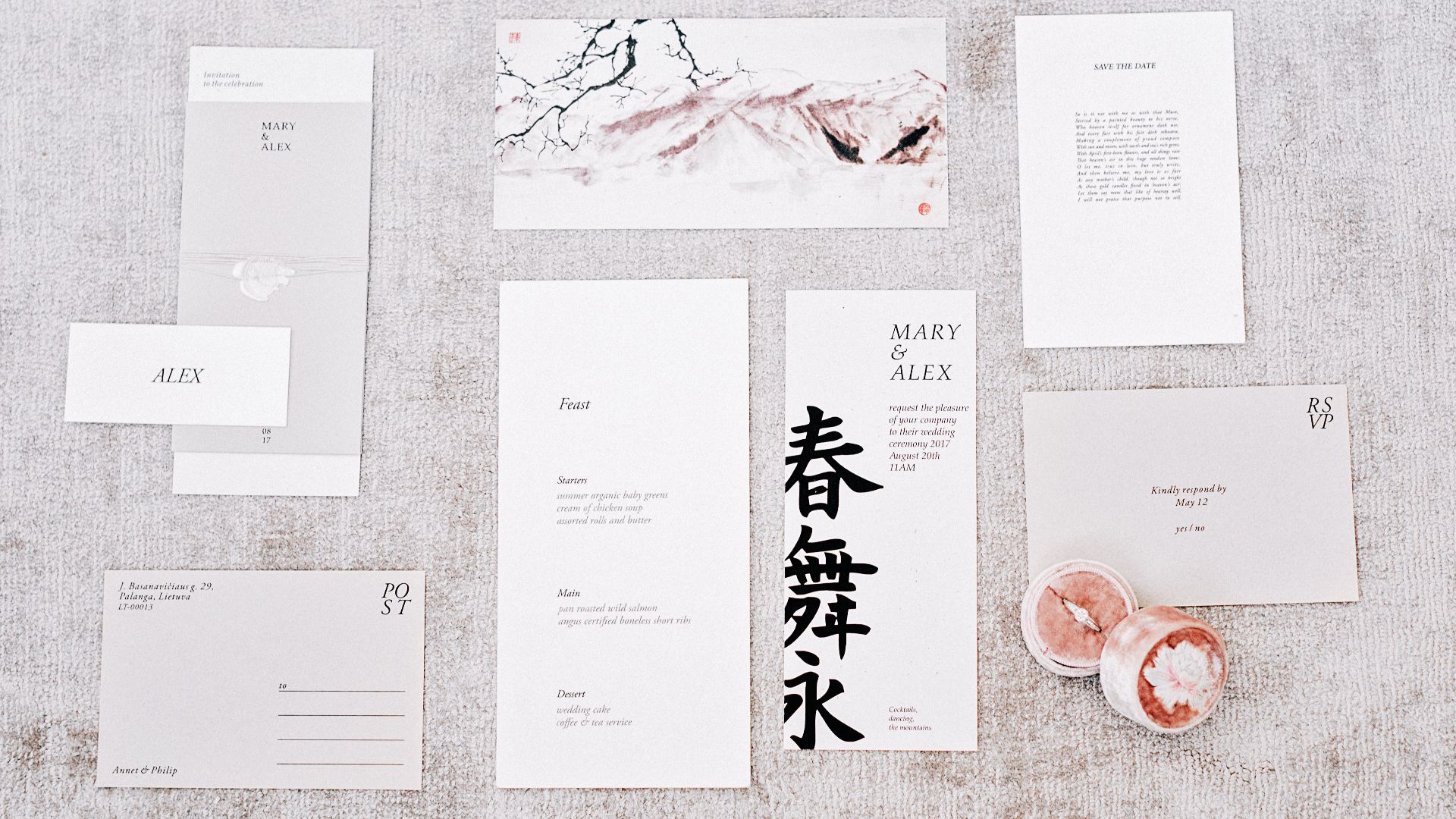 Elegant flat lay of wedding invitations with calligraphy and floral accents.
