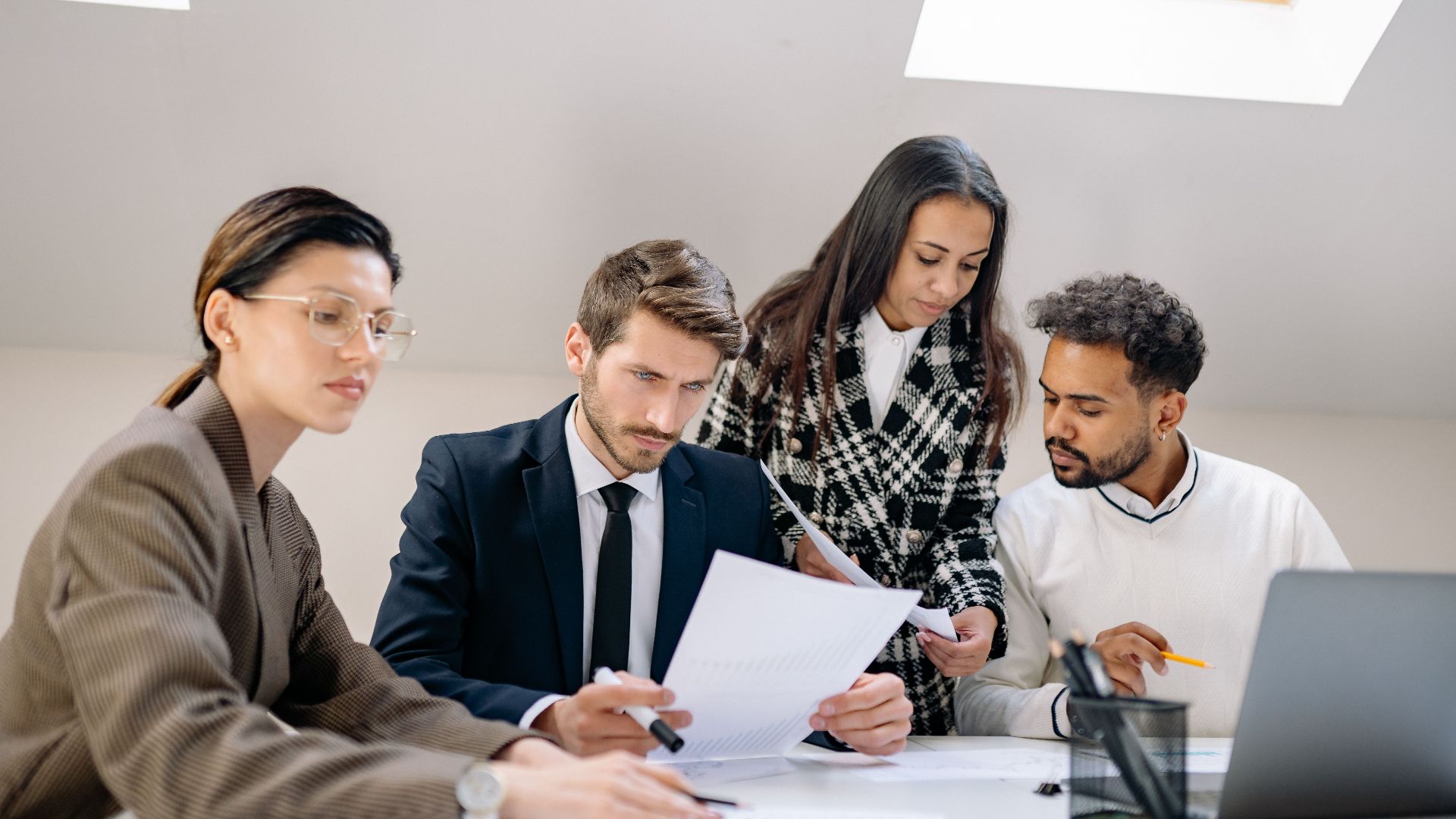 Diverse team working together in an office, discussing documents and strategies.