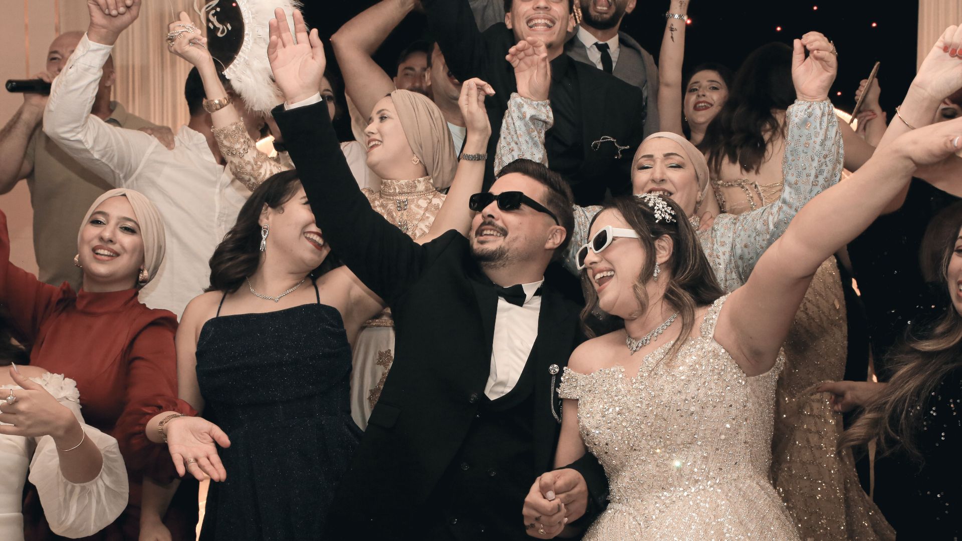 A lively wedding celebration with guests cheerfully dancing and celebrating together.