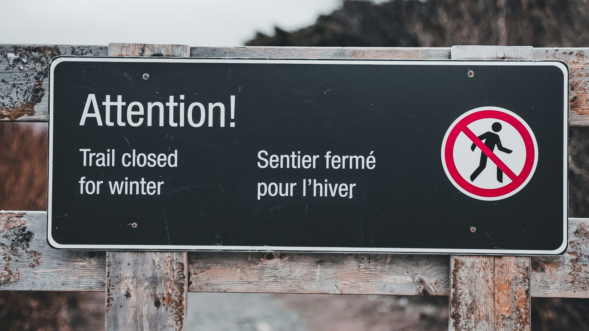 A sign that is on a wooden fence
