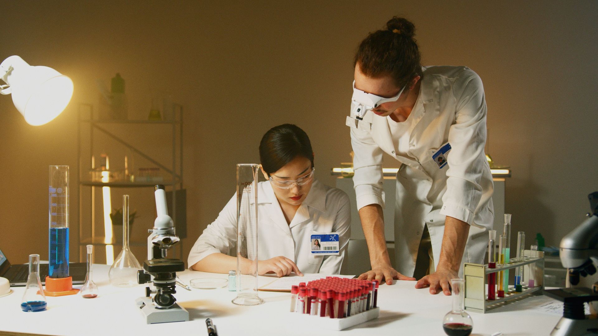 Two scientists working in a laboratory conducting experiments with various equipment and samples.