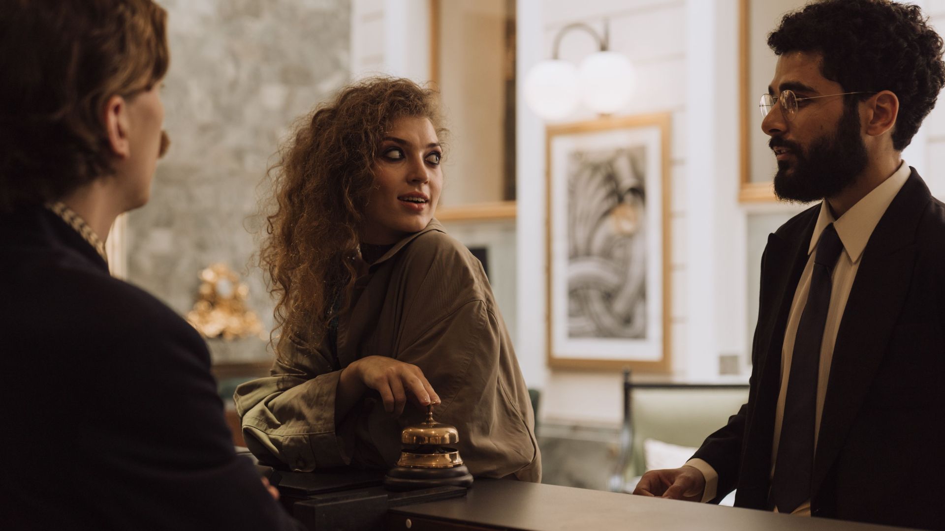Guests interacting at a luxurious hotel reception desk, emphasizing hospitality and service.