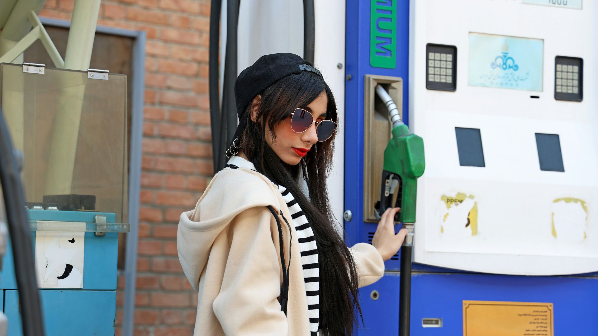 Woman holding gas pump at station
