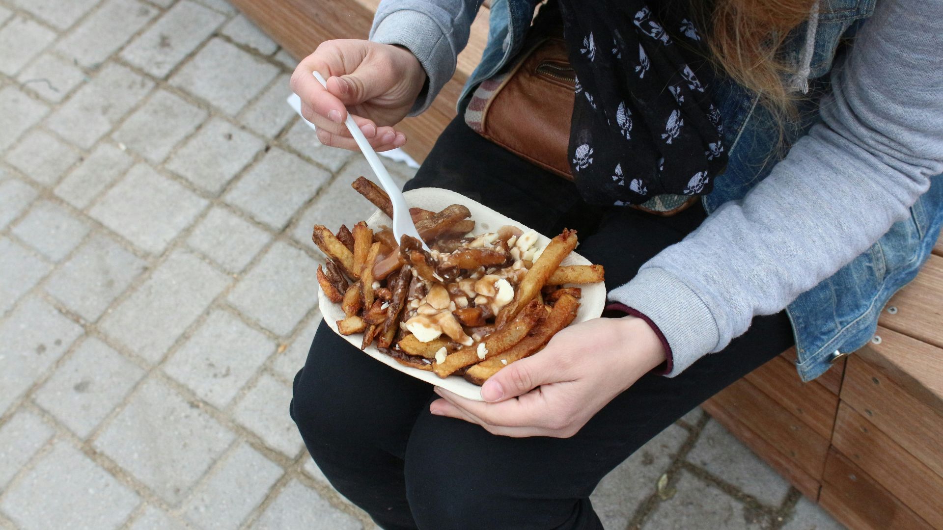 person holding burger with fries
