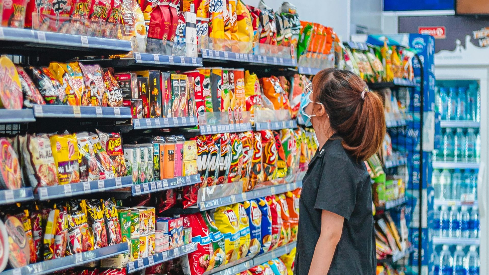 a woman standing in front of a display of food