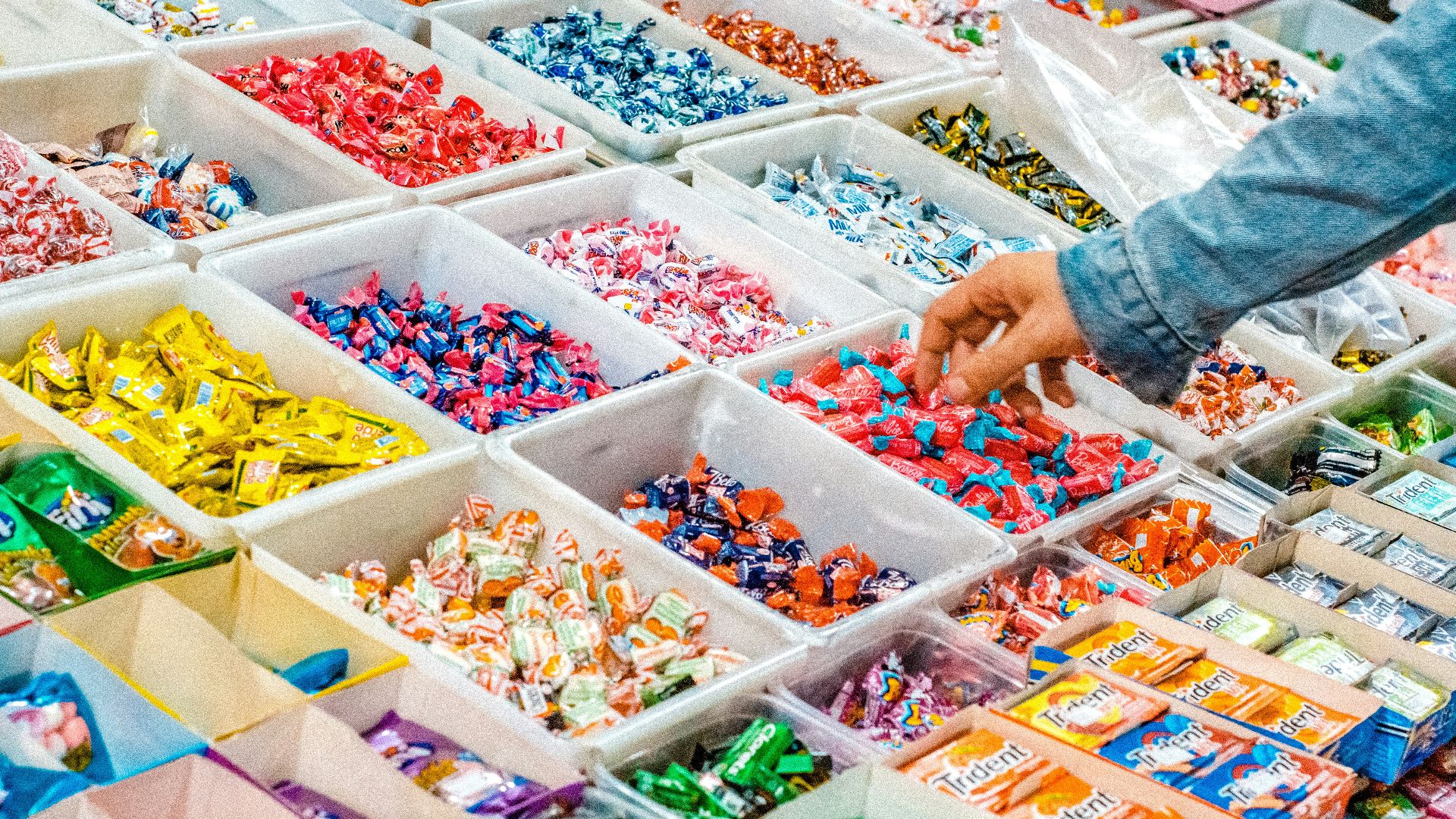 person holding a candy pack on white plastic box