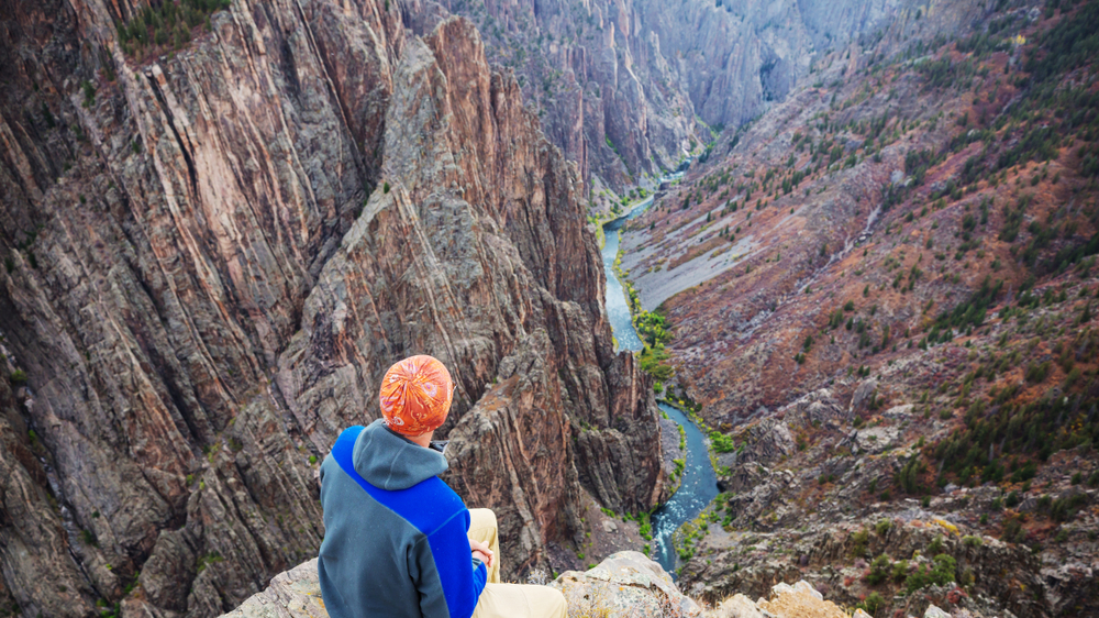 Tourist on the granite cliffs of the Black Canyon of the Gunnison, Colorado, USA
