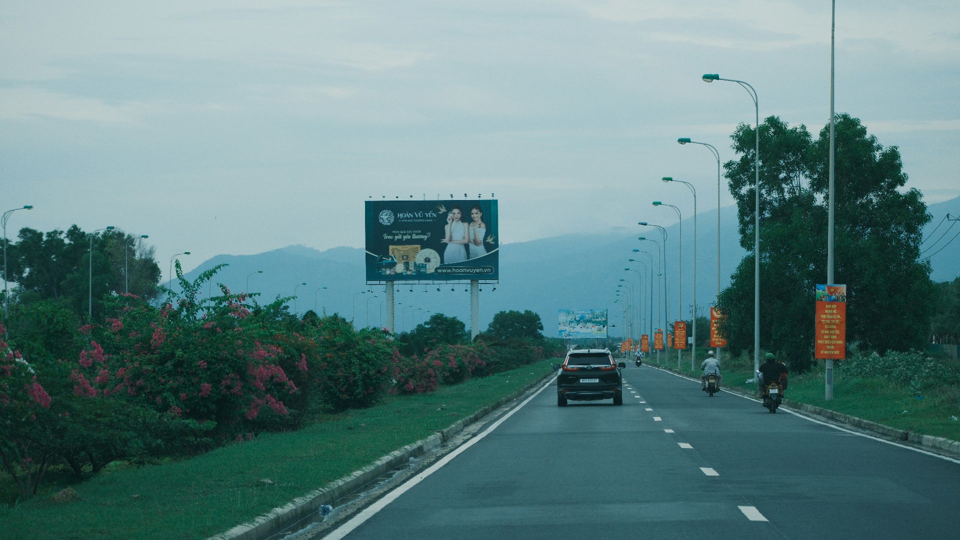 Car on highway with billboard and streetlights