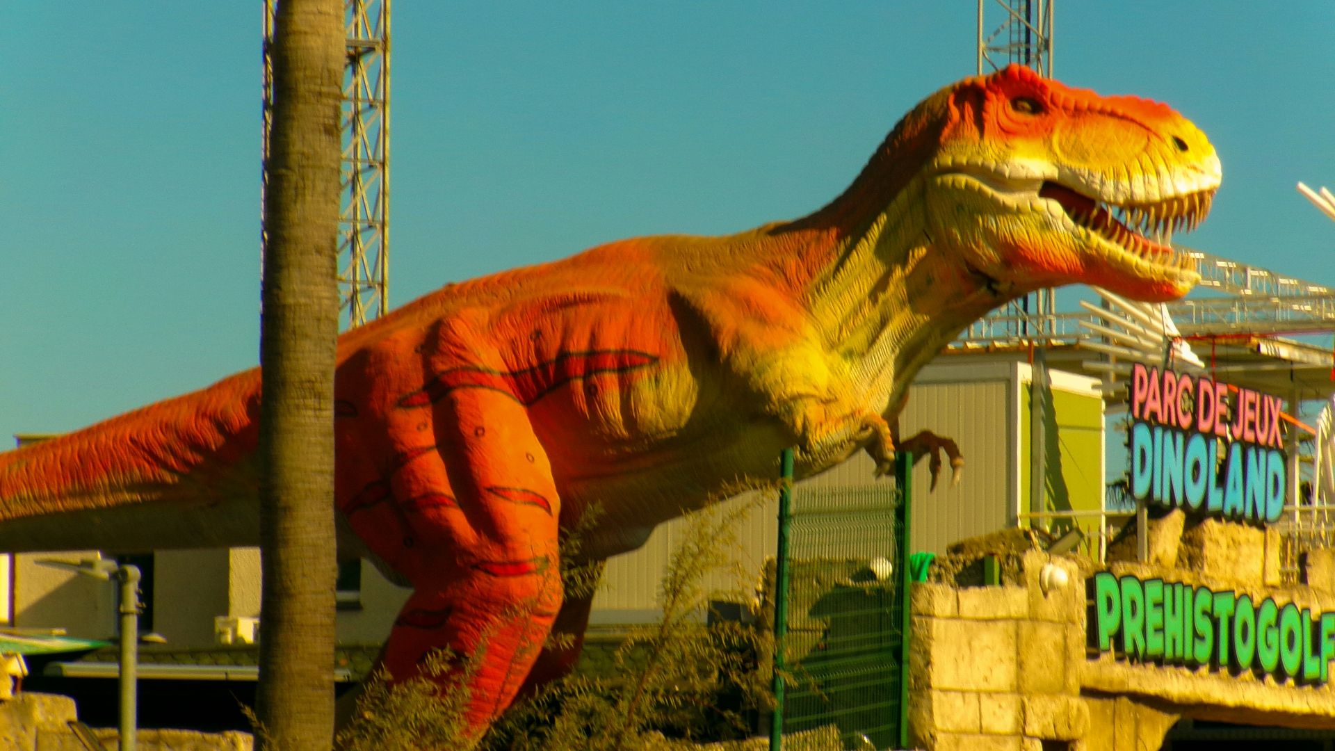 Large orange dinosaur statue at dinoland amusement park.