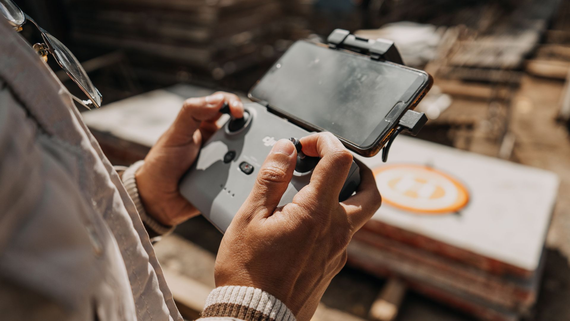 Close-up of a person operating a drone with a controller outdoors.
