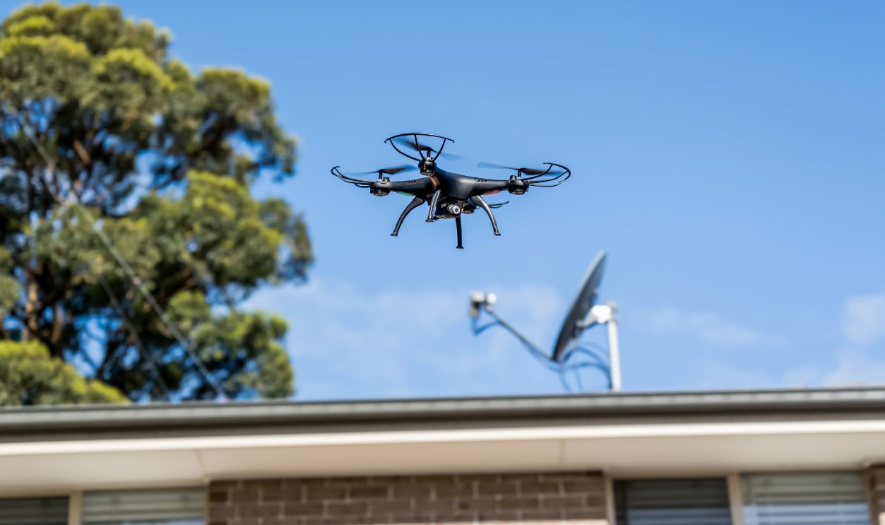 Drone camera quad copter flying over the roofs. Drone photography and videography. Drone flight in the sky
