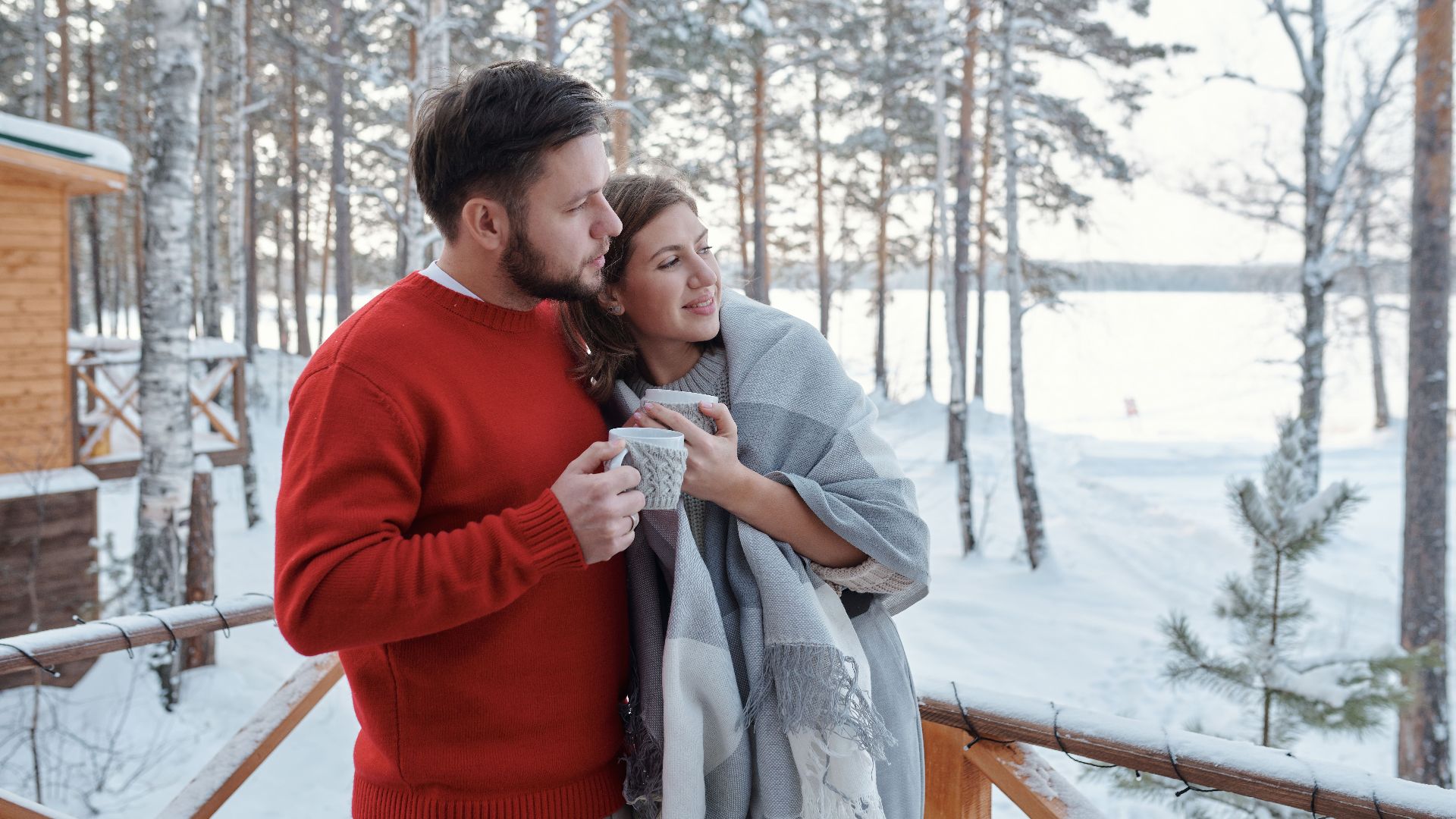 A cozy couple sharing hot coffee on a snowy winter morning.