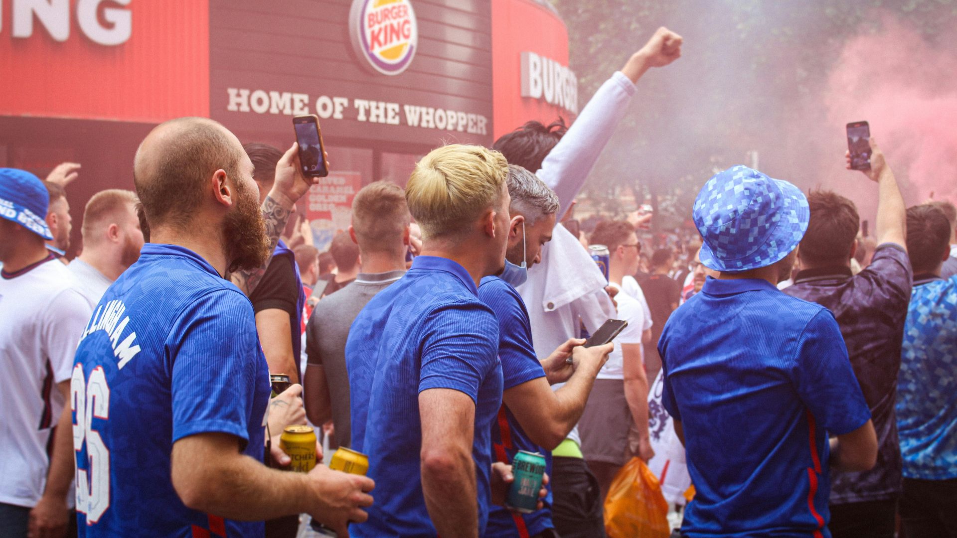 people in blue shirts standing and holding yellow and white powder