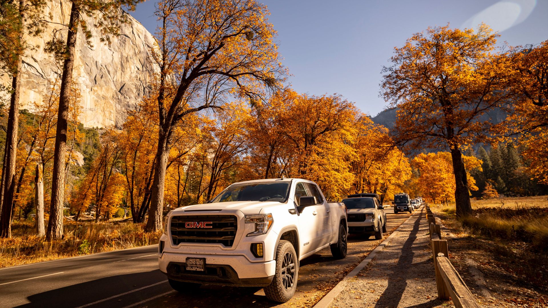 GMC trucks on a scenic autumn drive through Yosemite National Park with vibrant fall foliage.