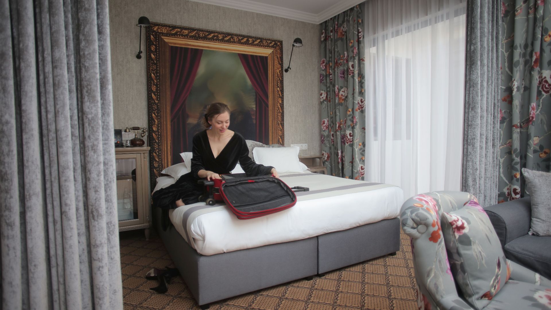 A woman in a chic hotel room packing her suitcase, ready for travel.