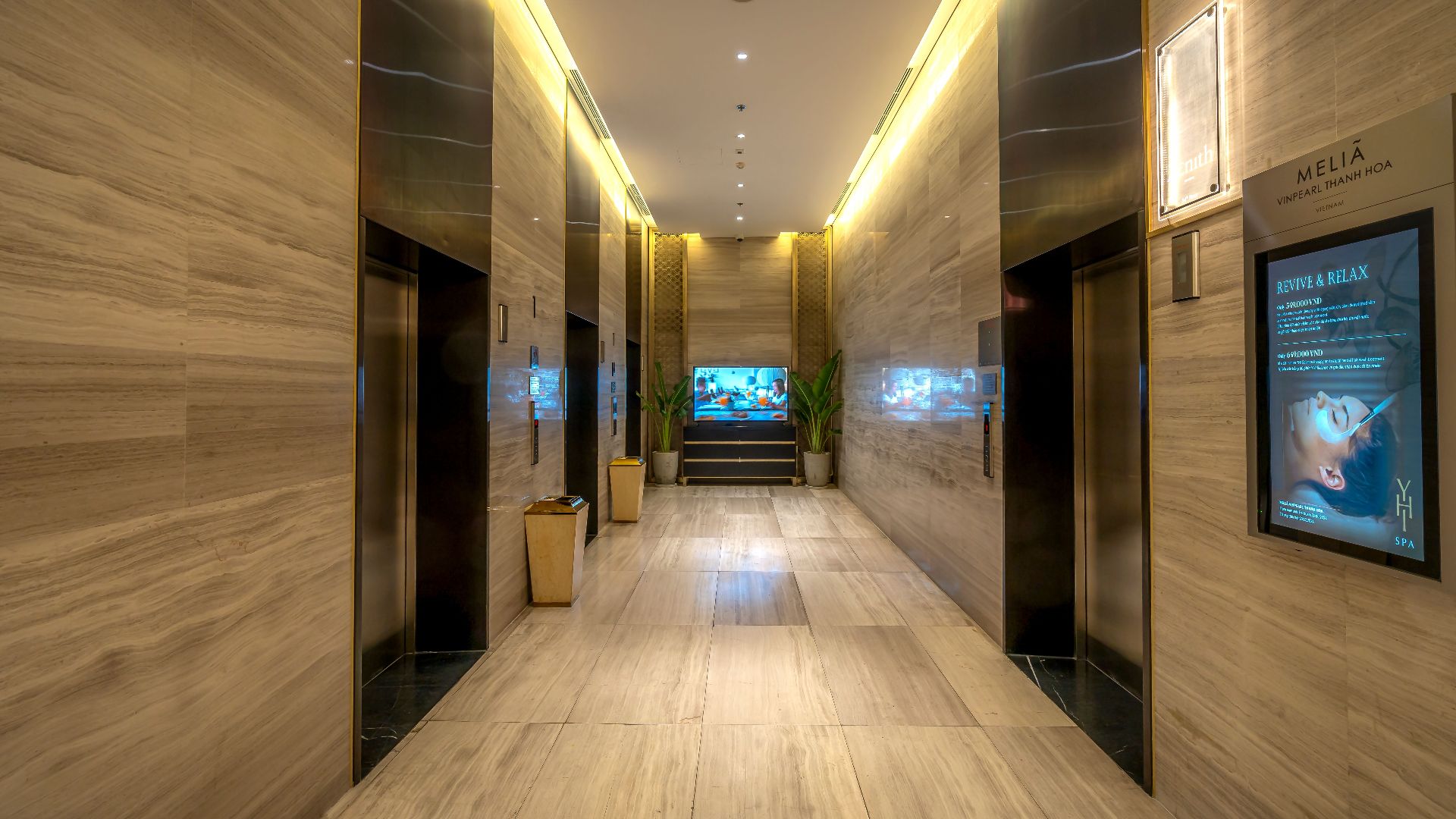 Elegant hotel corridor featuring marble floors and ambient lighting, exuding luxury.