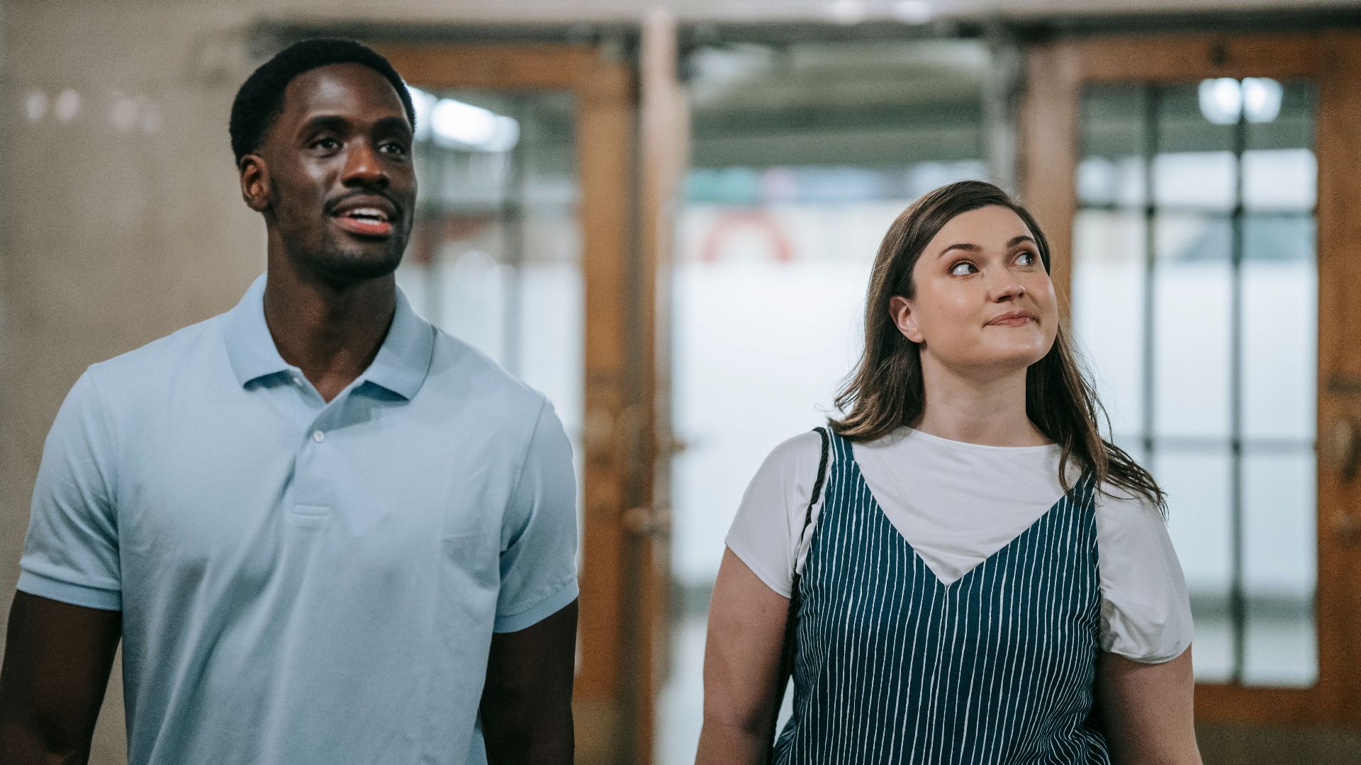 A diverse couple exploring an indoor urban environment together.
