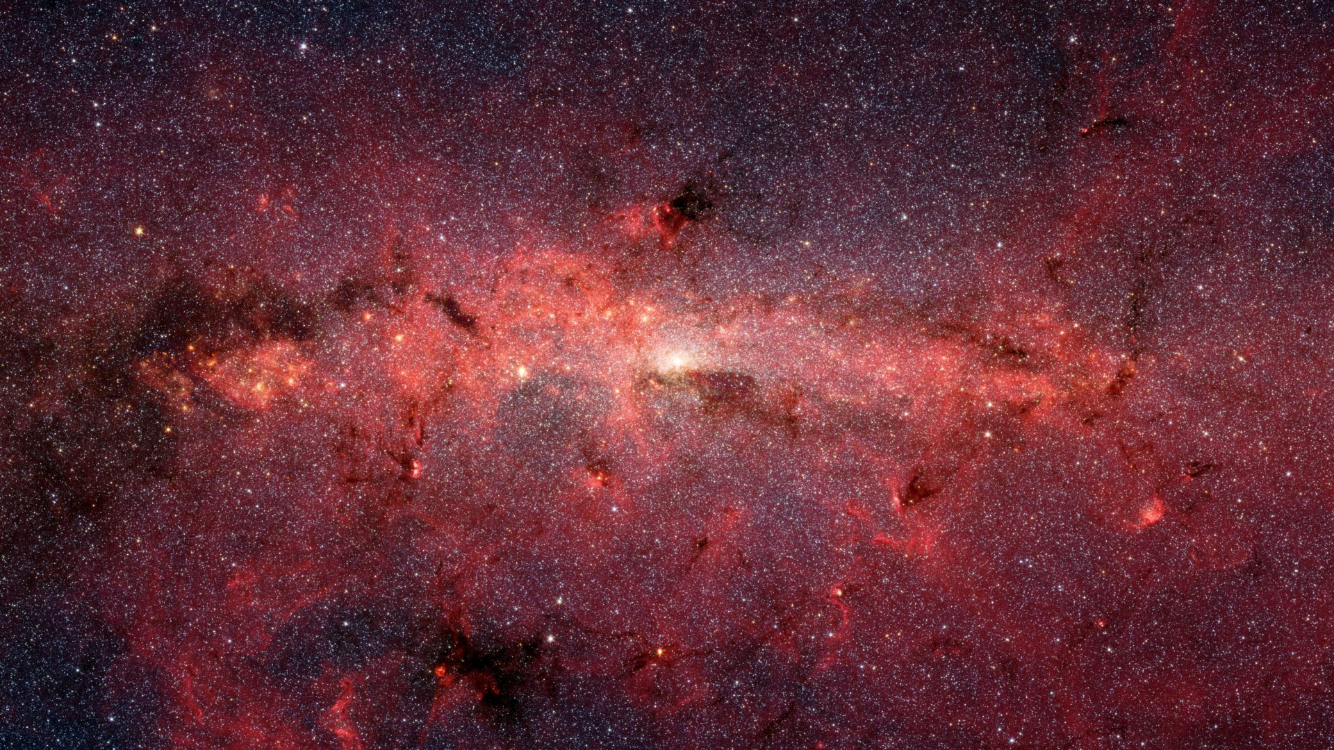The center of our Milky Way galaxy is hidden from the prying eyes of optical telescopes by clouds of obscuring dust and gas. But in this stunning vista, the Spitzer Space Telescope's infrared cameras penetrate much of the dust, revealing the stars of the 