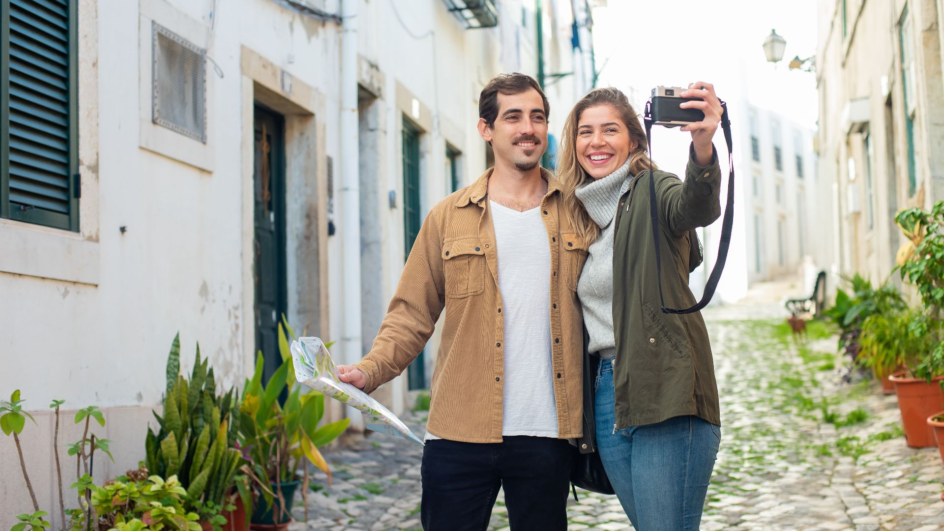 Joyful couple capturing memories in a picturesque city street.