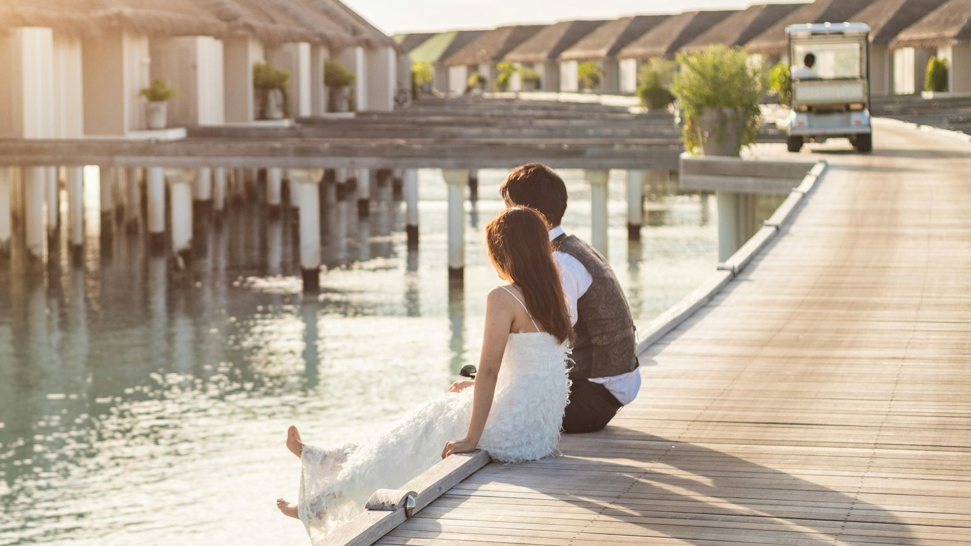 woman in white shirt sitting on dock during daytime