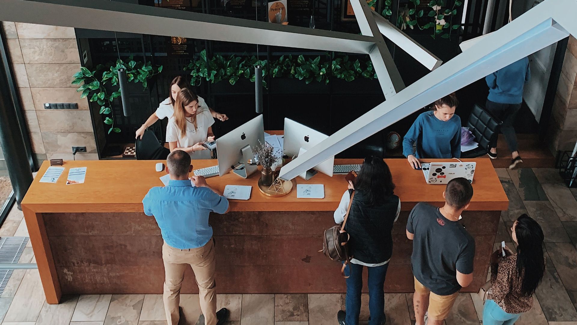 Aerial view of a modern hotel reception with people interacting at the desk in Sosnivka, Ukraine.
