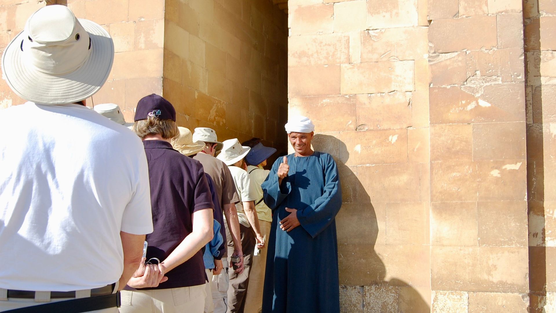 A local guide gives a thumbs up to tourists at a historic site in Cairo, Egypt.