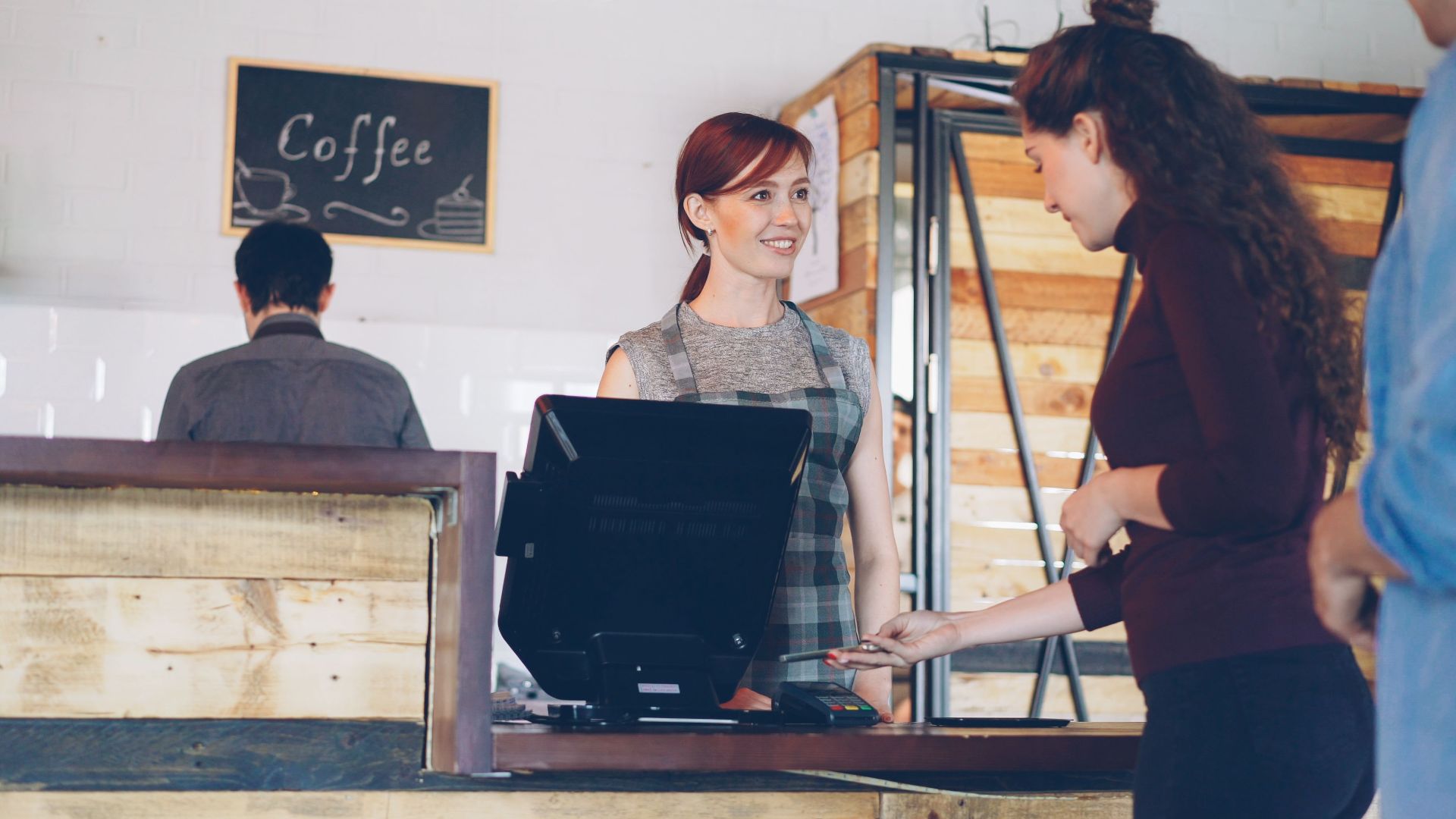 Barista serving customer in a charming coffee shop setting.