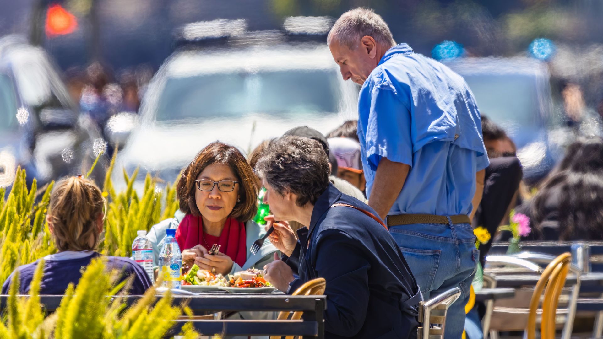 Social interaction in a vibrant street cafe setting with diverse diners.