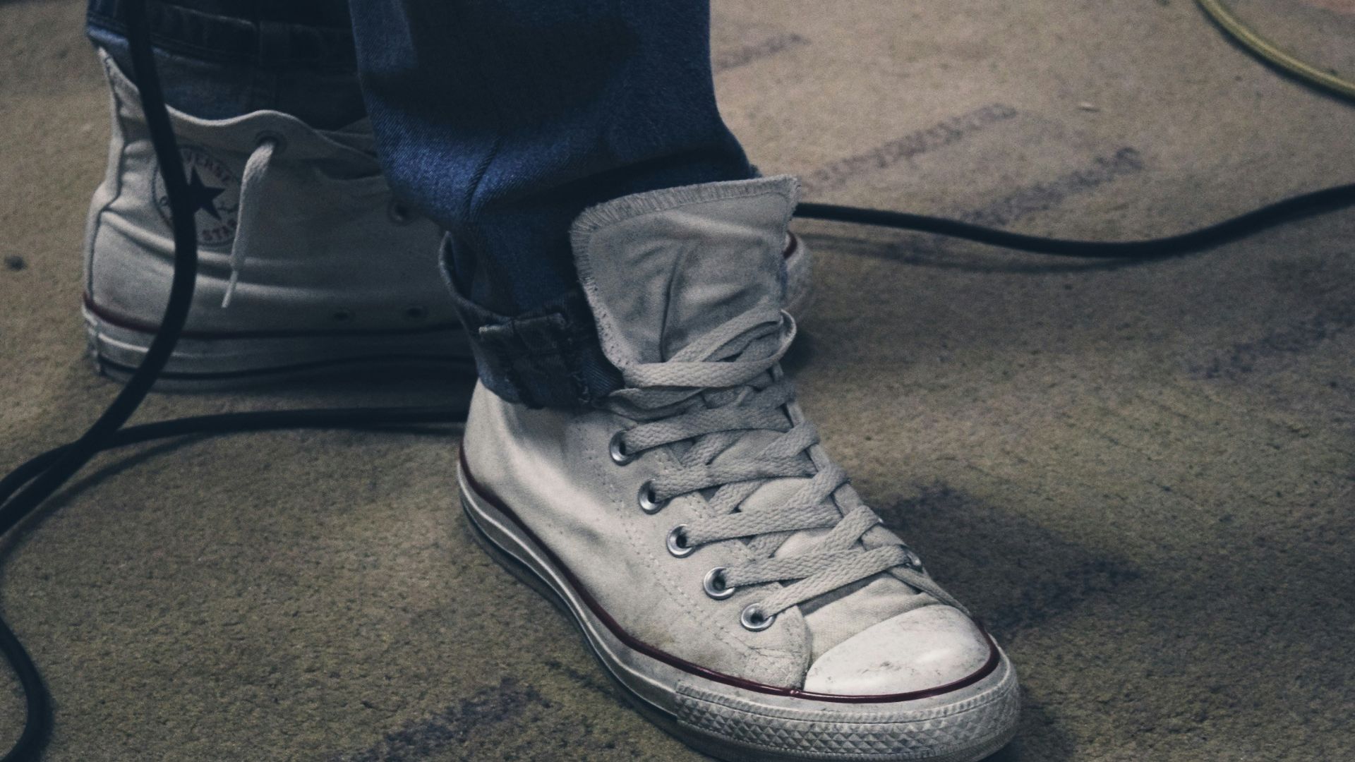 a person's feet with white sneakers