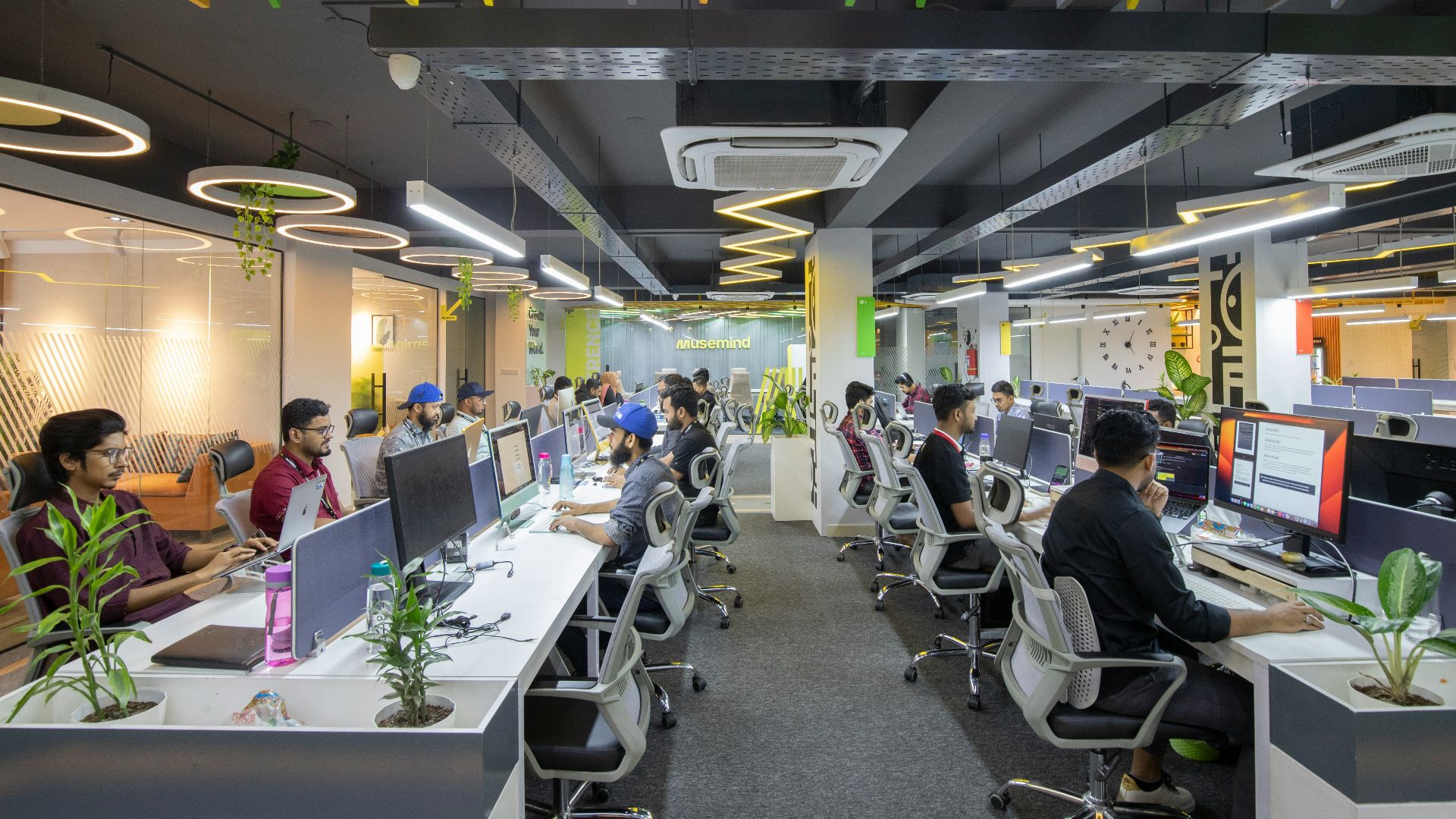 a group of people sitting at desks in an office