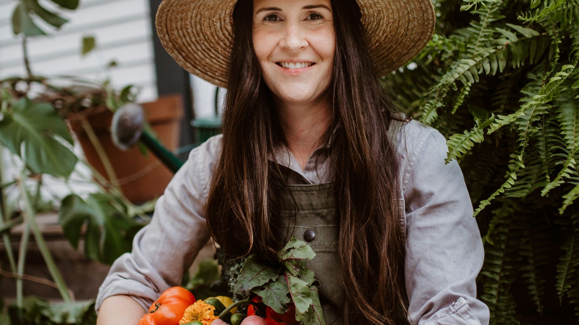 A woman sitting on a bench holding a bowl of vegetables