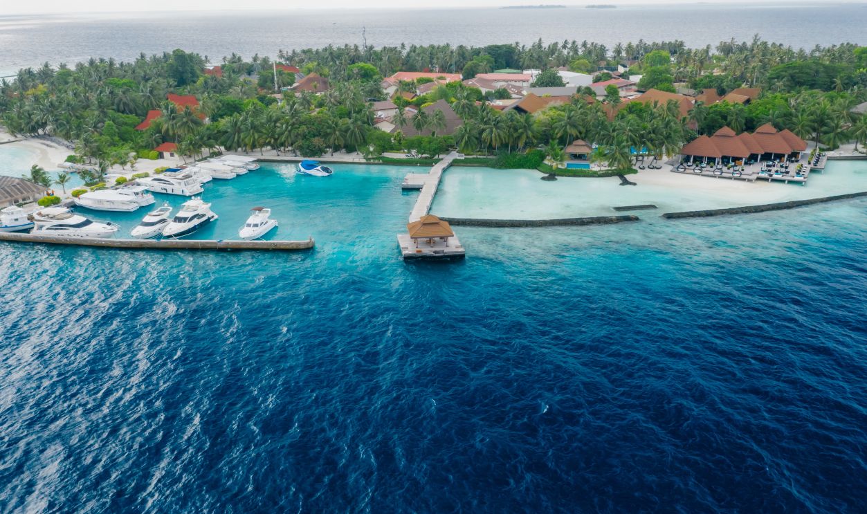 Stunning aerial shot of a tropical island resort featuring yachts and turquoise water
