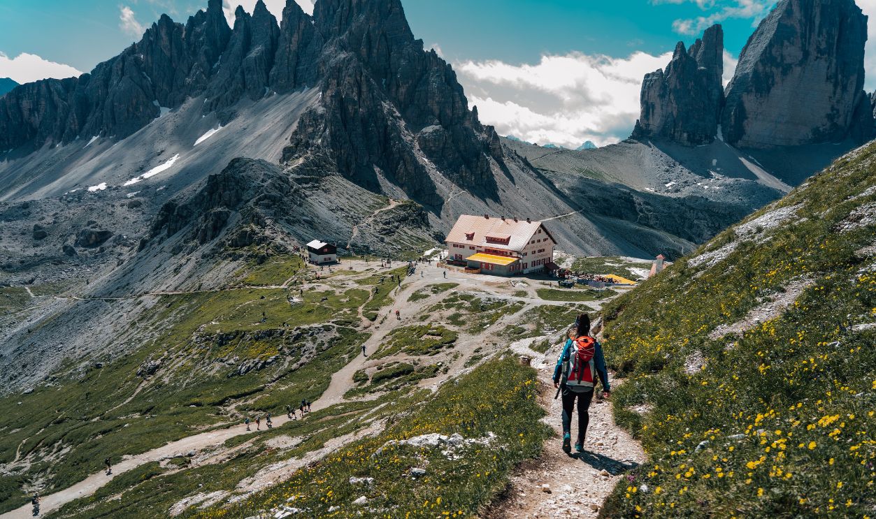 Woman hiking on a scenic trail in the Dolomites with stunning mountain views