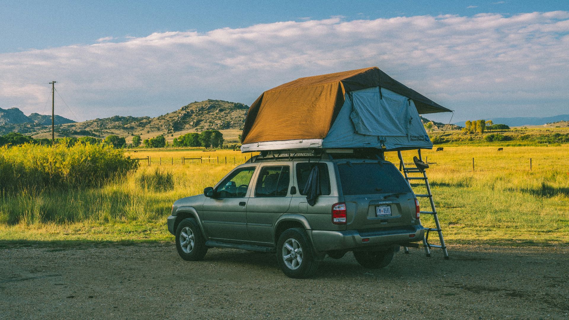 brown SUV parking with tent on top