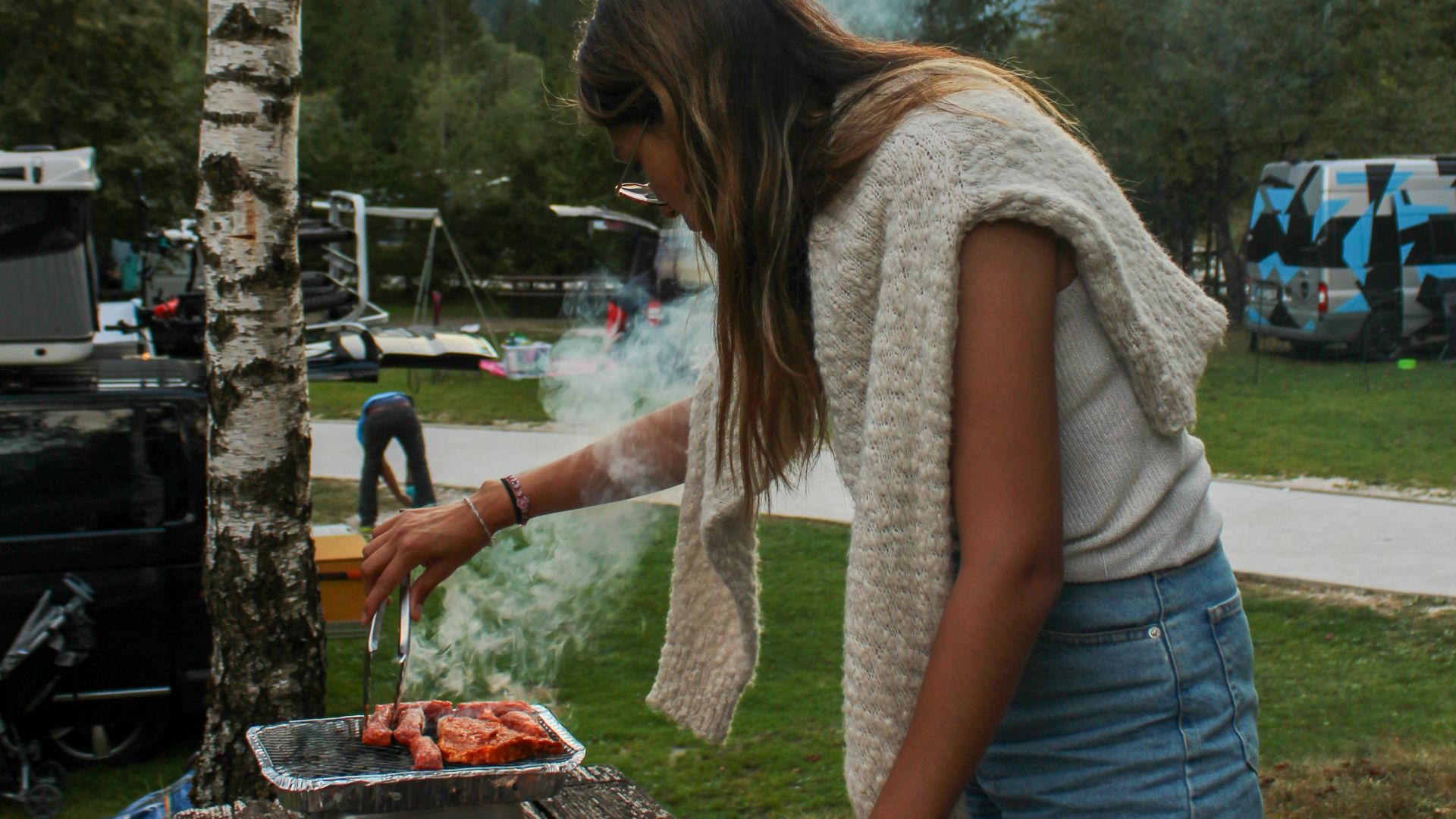 a woman standing over a table filled with food