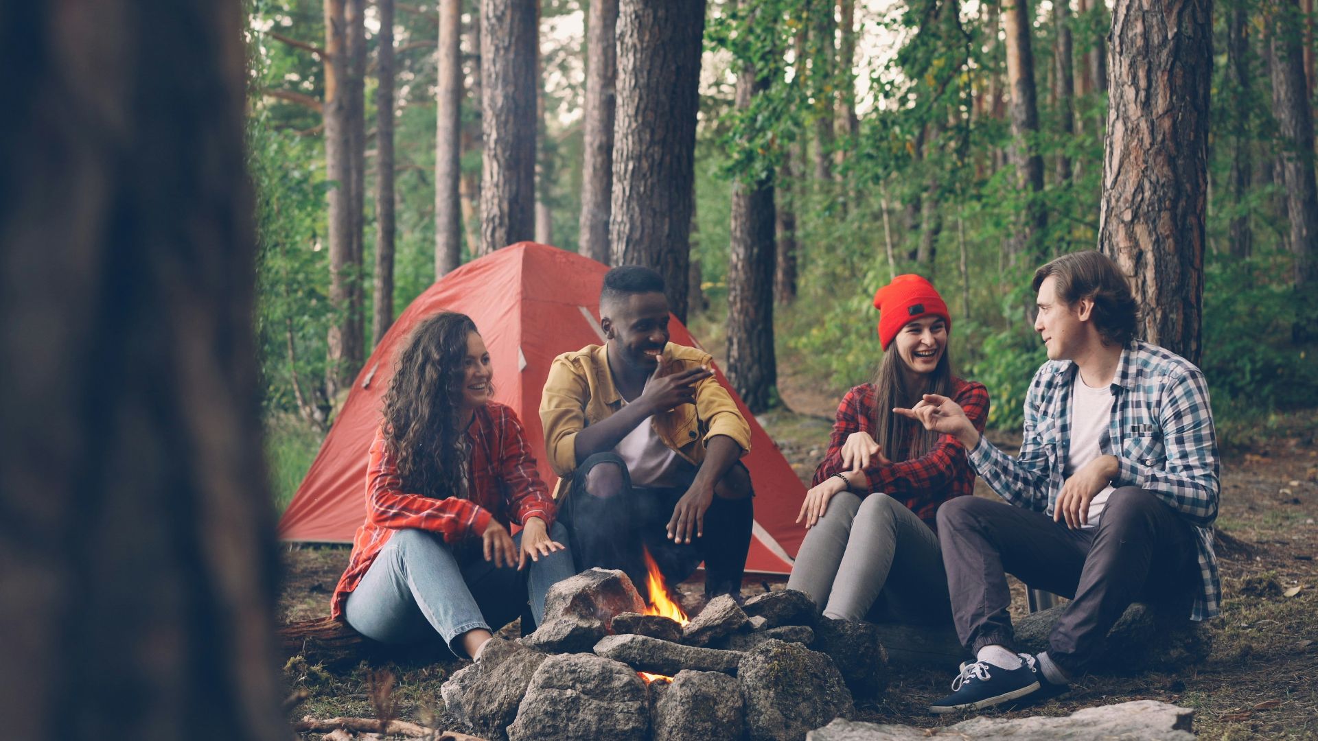 Friends gathered around a campfire in the woods.