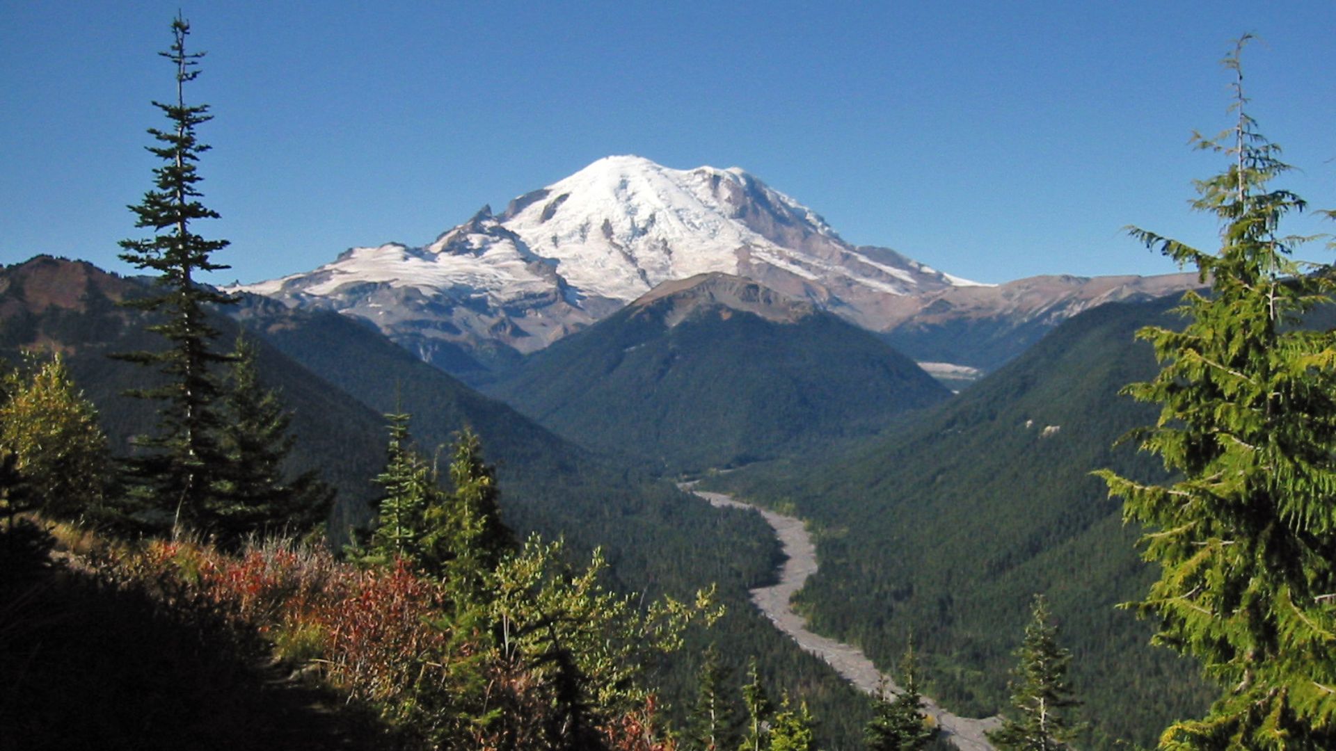 Mount Rainier with its main summit, Columbia Crest (14410 feet) at the center. Liberty Cap (14112 feet) is to the right behind Russell Cliff. Curtis Ridge descends to the right from Russell Cliff. Massive Emmons Glacier covers most of the visible flank of