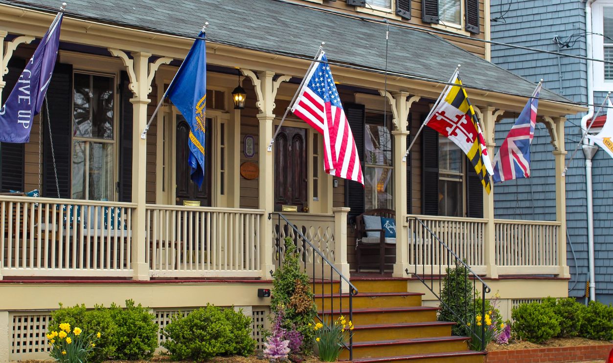 Historic house in Annapolis, Maryland, displaying various flags on a charming porch