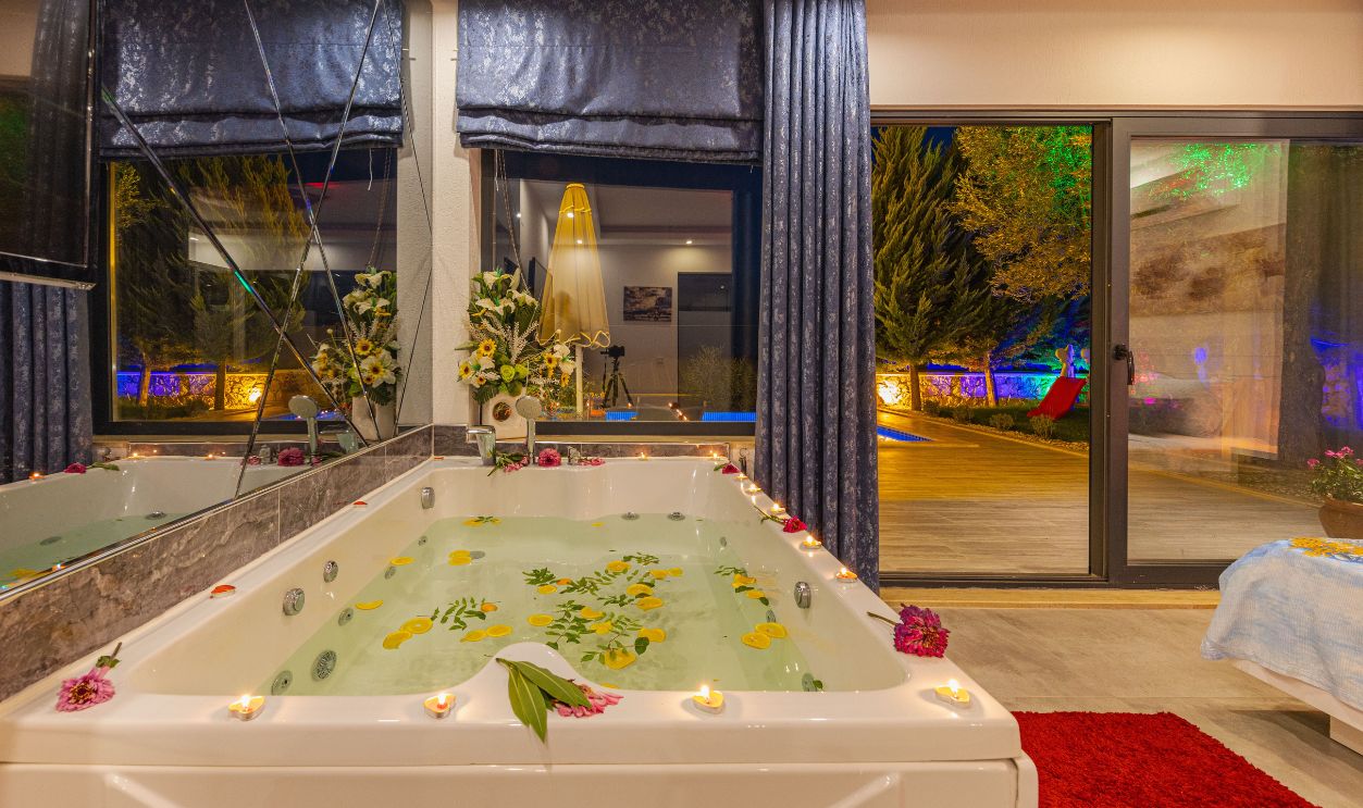Experience ultimate relaxation in a luxury indoor jacuzzi adorned with petals and ambient candlelight, perfect for a serene retreat