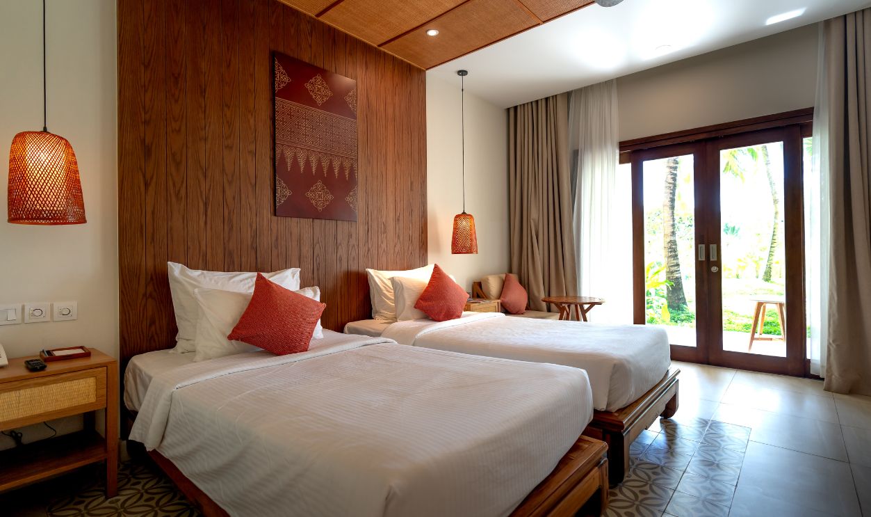 Contemporary hotel room featuring twin beds, wood accents, and large windows with garden view