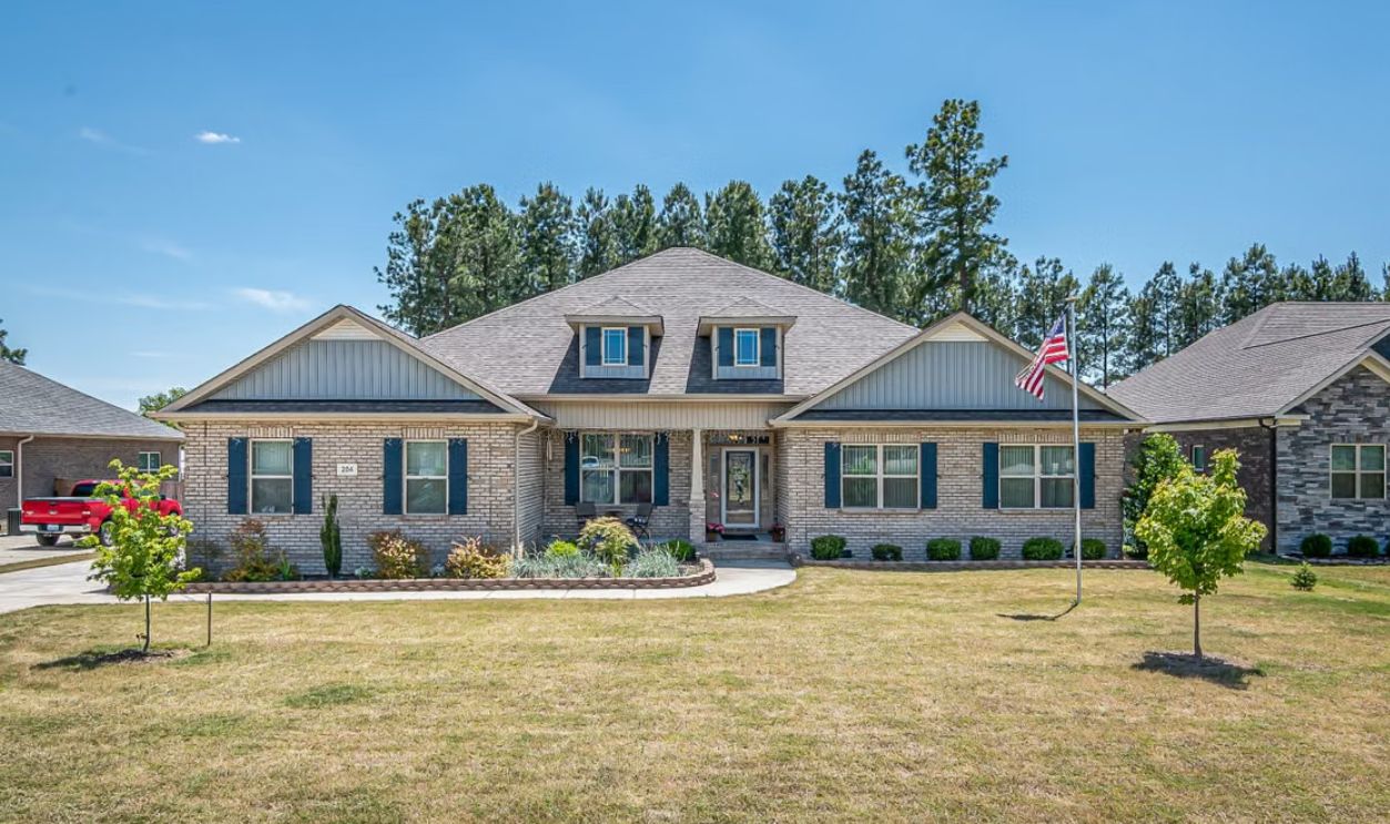 Charming brick family home in suburbia with American flag and manicured lawn