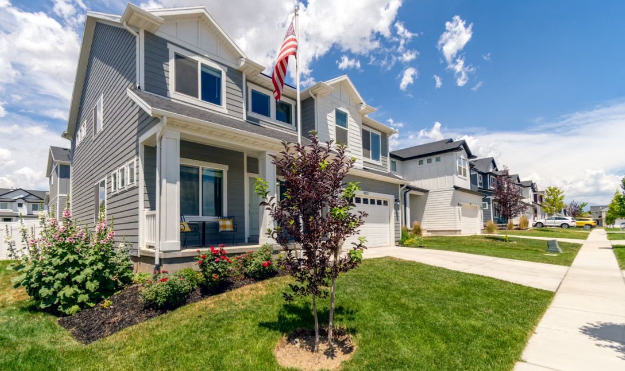 A modern suburban house with garden and American flag, showcasing beautiful architecture