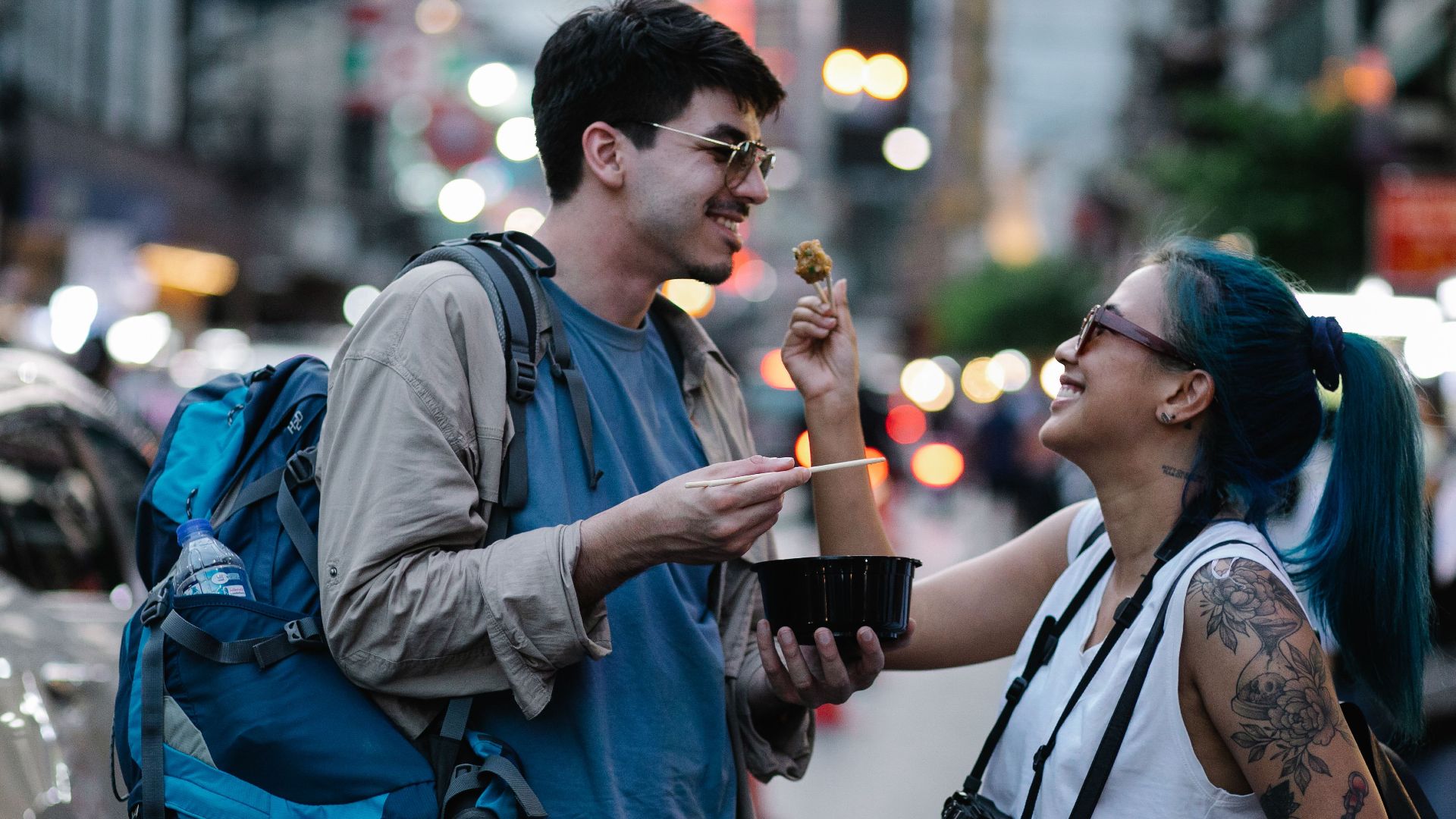 A couple enjoying street food in a lively city scene, capturing moments of joy and adventure.