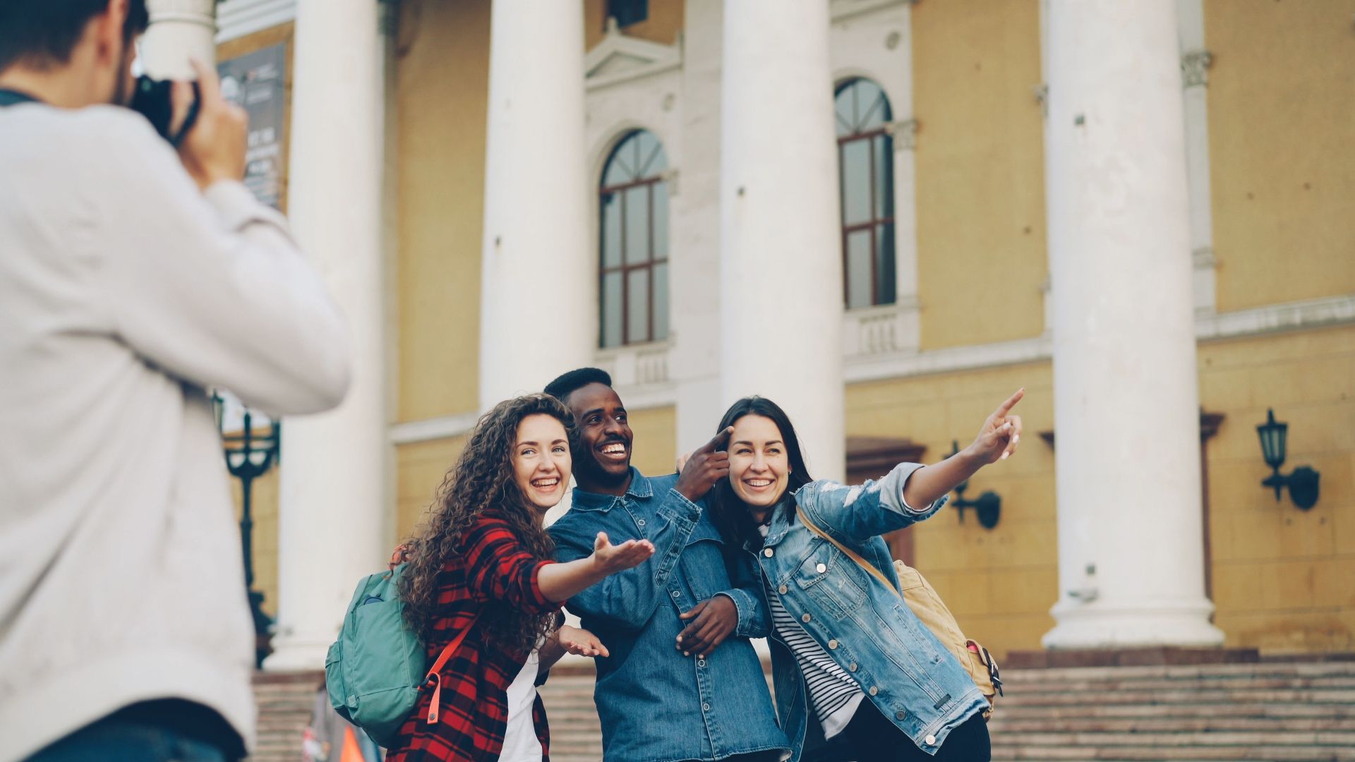 Three friends posing for a photo near a historic building with columns.