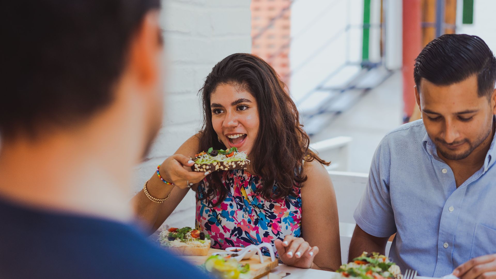 A group of friends enjoying a casual lunch with healthy food at a vibrant cafe.