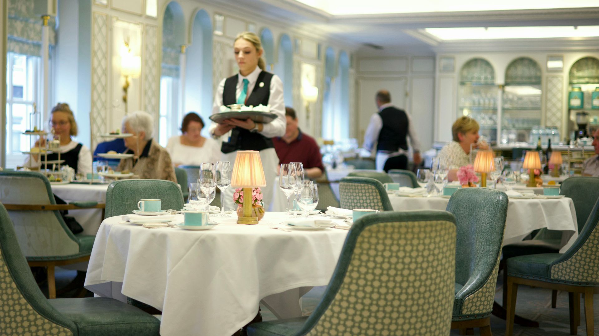 Upscale restaurant setting with a waitress serving guests, creating a luxurious dining experience.